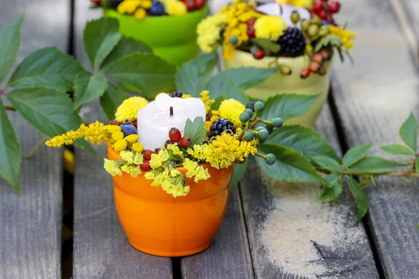 मोमबत्ती धारक शरद ऋतु के फूलों और अन्य पौधों से सजाया गया है। से — स्टॉक फ़ोटो, इमेज