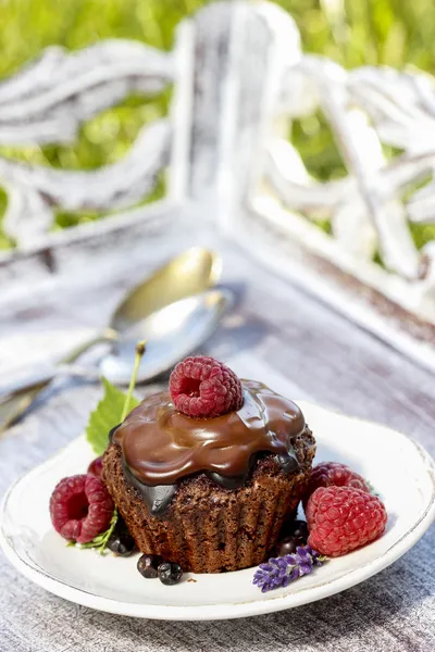 Schokoladenkuchen mit frischen Früchten auf Holztablett im Garten — Stockfoto