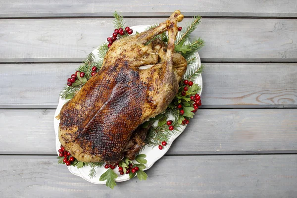 Pečená husa na dřevěný stůl. populární vánoční pokrm — Stock fotografie