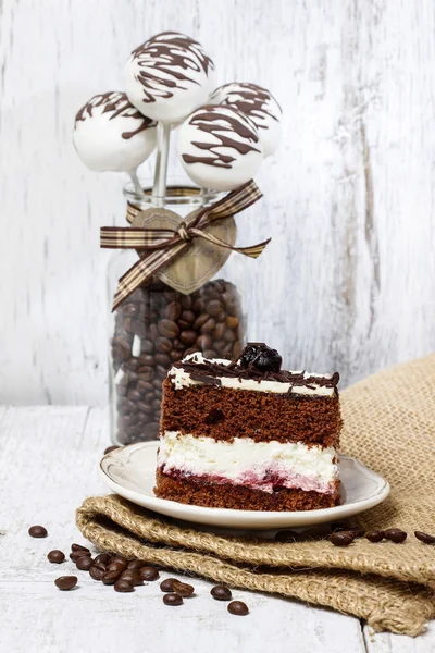 Cake, chocolade en kersen. koffiebonen rond, houten terug — Stockfoto