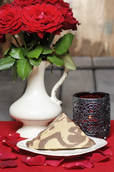 Stück Halwa auf weißem Teller. Rosenblätter herum — Stockfoto