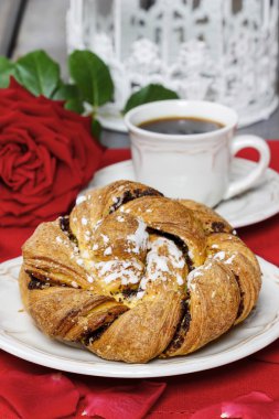 Beyaz tabakta şenlikli örgülü ekmek. gül yaprakları etrafında, bouque