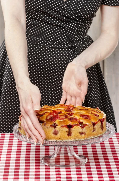 Woman holding strawberry pie on cake stand. Party table — Stock Photo, Image