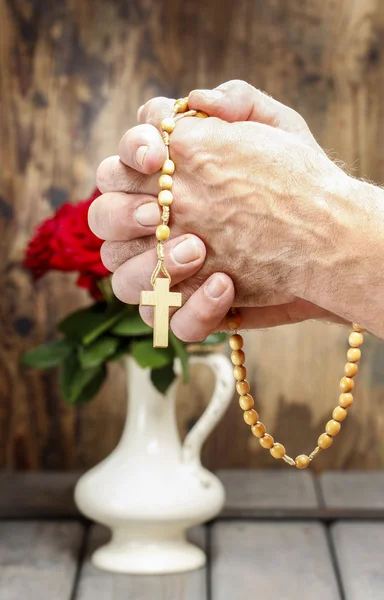 Ręce, trzymając różaniec drewniany — Zdjęcie stockowe