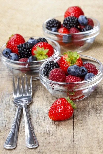 Fruit salad in small transparent bowls on wooden table — Stock Photo, Image