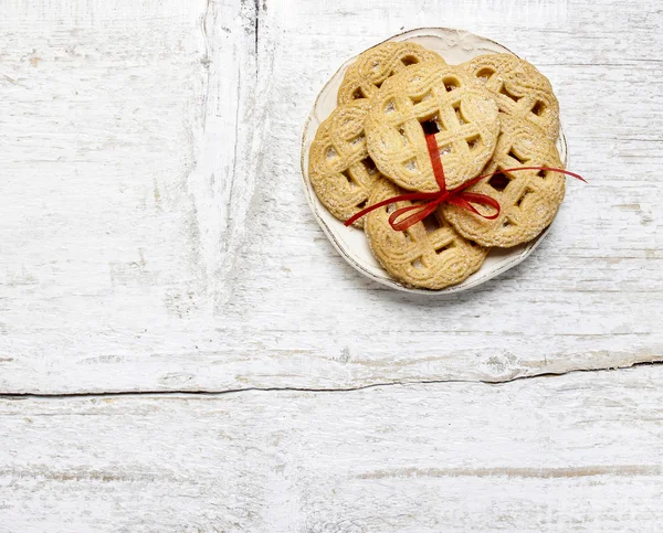 Vista superior de cookies com arco vermelho na mesa de madeira branca — Fotografia de Stock