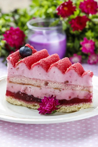 Розовый слой торт украшен свежими фруктами на деревянном столе — стоковое фото