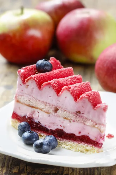 Růžové vrstvy dort s čerstvým ovocem na dřevěný stůl — Stock fotografie