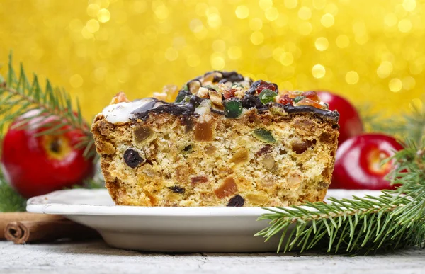 Bolo de frutas com frutas secas e nozes no cenário de Natal — Fotografia de Stock