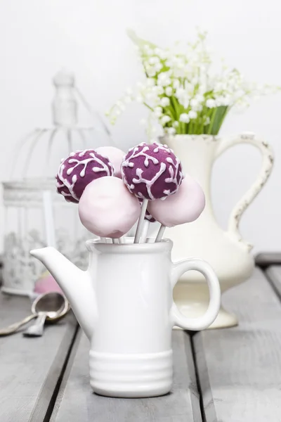 Pastel cake pops on rustic grey wooden table. Bouquet of lilly — Stock Photo, Image