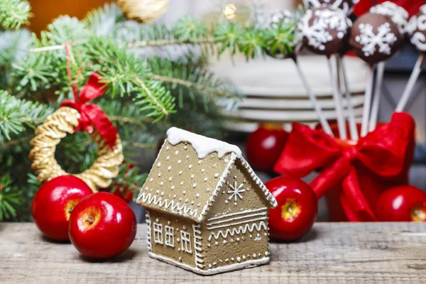 Lebkuchenhaus am Tannenzweig auf dem Weihnachtstisch — Stockfoto