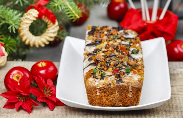 Fruitcake with dried fruits and nuts in christmas setting — Stock Photo, Image