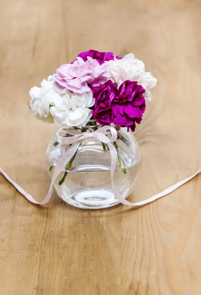 Bouquet di fiori di garofano in vaso di vetro su tavolo di legno. Oro — Foto Stock