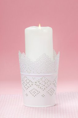 Beyaz, pembe bir arka plan üzerinde beyaz Mumluk mum