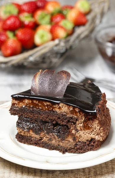 Čokoládový dort a košík čerstvé syrové jahod pozadí — Stock fotografie