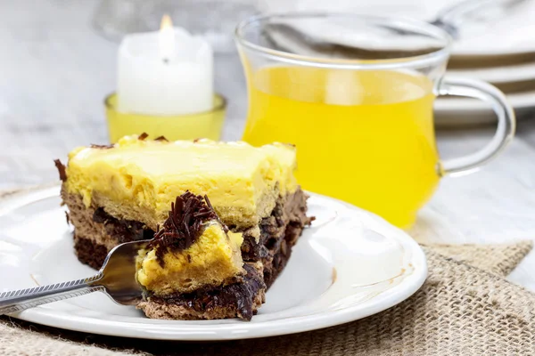 Pedazo de pastel amarillo y marrón en la mesa de madera. Enfoque selectivo — Foto de Stock