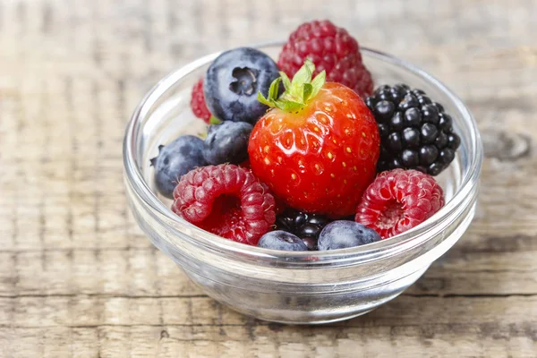 Fruitsalade in transparante kommetje op houten tafel — Stockfoto