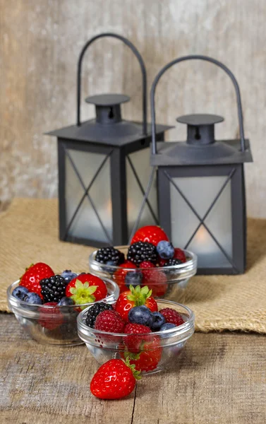 Salade de fruits dans de petits bols sur une table en bois. Lanternes en fer noir — Photo