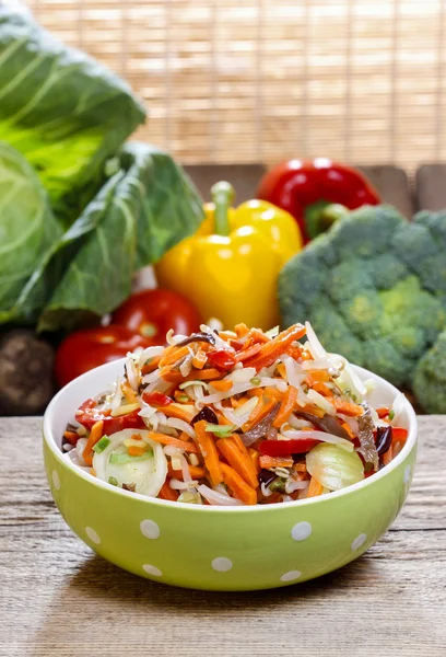 Färska grönsaker sallad i grön prickig skål. råa grönsaker — Stockfoto
