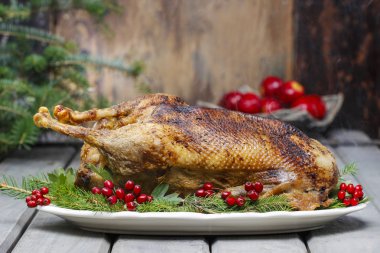 Baked goose on wooden table. Popular christmas dish clipart