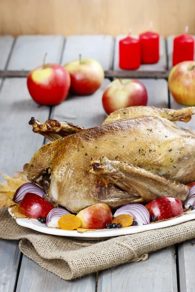 Oie rôtie aux pommes et légumes sur table en bois . — Photo