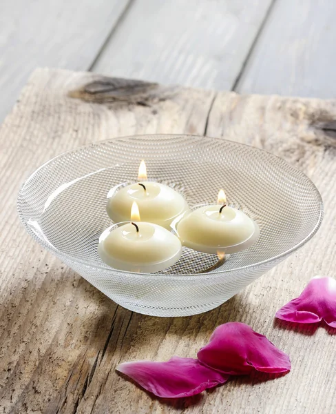 Velas flotantes en agua entre pétalos de rosa. Aromaterapia en spa —  Fotos de Stock