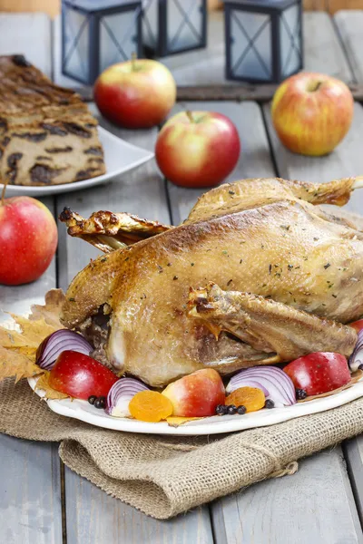 Roasted goose with apples and vegetables on wooden table. — Stock Image Roasted goose with apples and vegetables on wooden table. Stock Photo