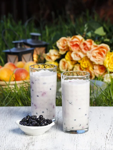 Blueberry smoothie on wooden table. Summer party, flowers and fr — Stock Photo, Image