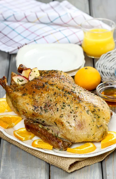 Gebratene Ente mit Orangen auf Holztisch — Stockfoto