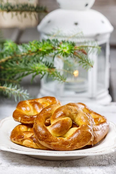 Christmas pretzel under fir branch. White candle in iron lantern — Stock Photo, Image