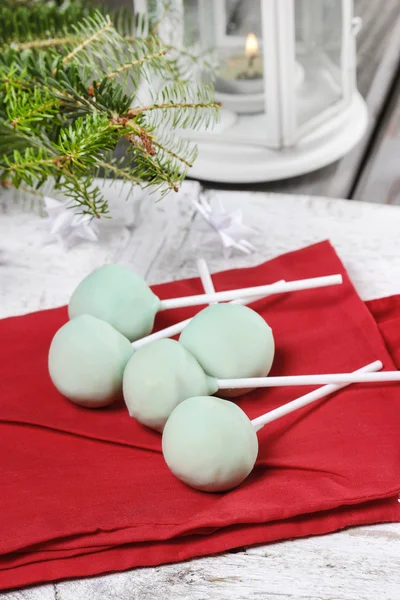 El pastel verde aparece en la servilleta roja. Postre de Navidad sobre mesa de madera —  Fotos de Stock