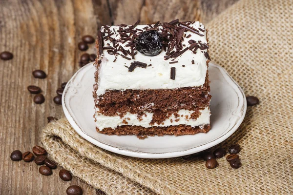 Vişneli ve çikolatalı kek. ahşap arka tarafta kahve çekirdekleri — Stok fotoğraf