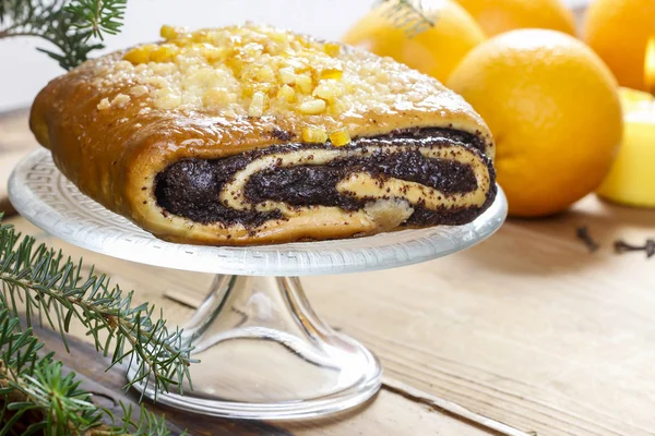 Poppy seed cake on glass cake stand under fir branch — Stock Photo, Image