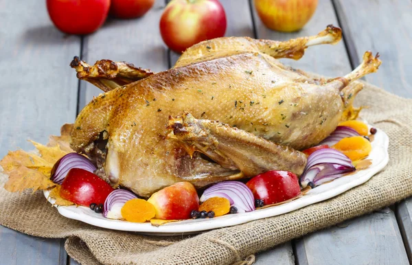 Roasted goose with apples and vegetables on wooden table. — Stock Image Roasted goose with apples and vegetables on wooden table. Royalty Free Stock Images