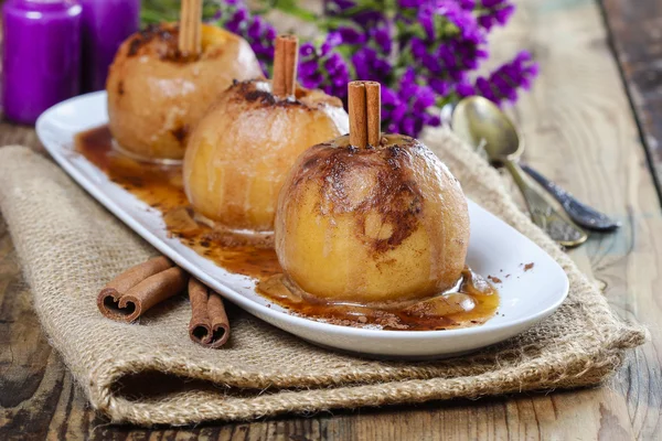 Apples with cinnamon on jute napkin. Sea lavender in the back — Stock Photo, Image