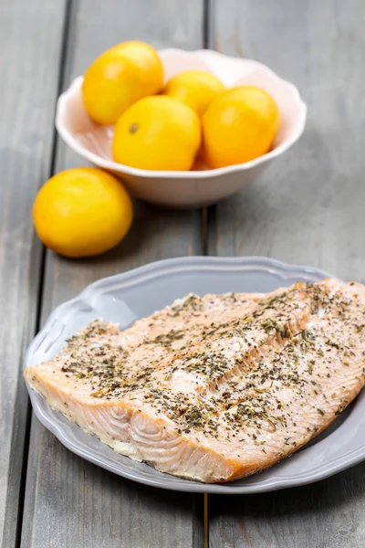 Gebackener Lachs auf grauem Teller. frisches Obst herum. leckerer Feiertag — Stockfoto