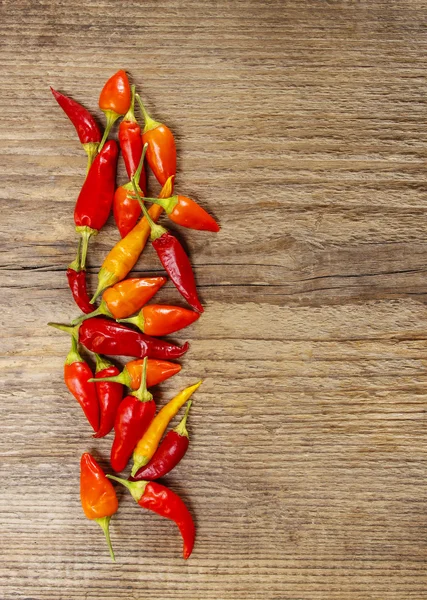 Chiles rojos picantes sobre fondo de madera. Copiar espacio — Foto de Stock