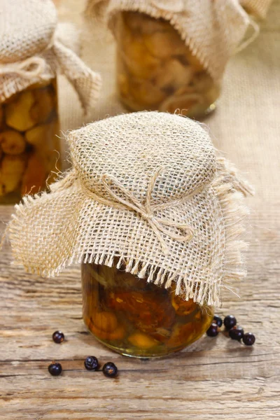 Pickled mushrooms in transparent glass jar — Stock Photo, Image