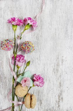 pembe karanfil çiçek ve ahşap masa sweets. Üstten Görünüm
