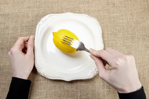 Hungrige Frau, die Zitrone isst. Symbol für Schlankheitswahn — Stockfoto