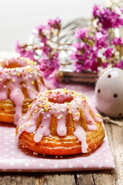 Tradiční velikonoční kvasnic dort pokrytý růžovou polevou a barevné BL — Stock fotografie