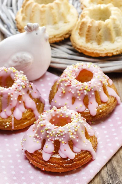 Traditional easter yeast cake covered with pink icing and colorf — Stock Photo, Image