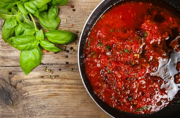 Red sauce made of dried tomatoes on frying pan. Wooden backgroun — Stock Photo, Image