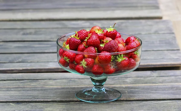 Glass bowl of fresh ripe strawberries on rustic wooden table. — Stock Photo, Image