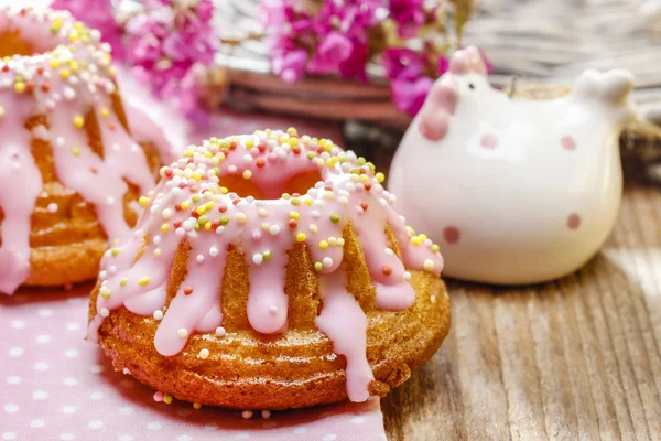 Traditional easter yeast cake covered with pink icing and color — Stock Photo, Image