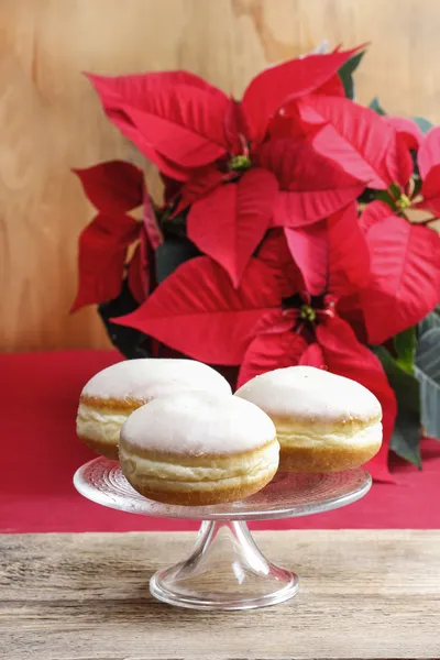 Donuts en el puesto de pasteles. Ajuste de Navidad, poinsettia en la espalda —  Fotos de Stock