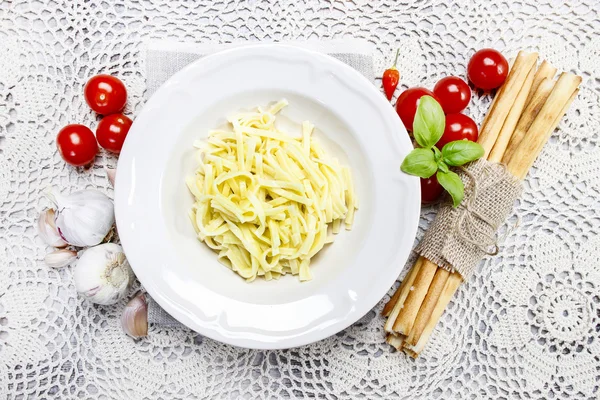 Top view on bowl of spaghetti, fresh vegetables and traditional — Stock Photo, Image