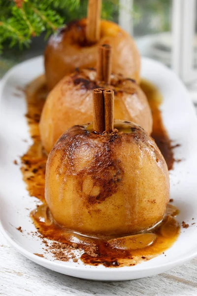 Karmelowe jabłka na biały drewniany stół. Choinka w plecy — Zdjęcie stockowe