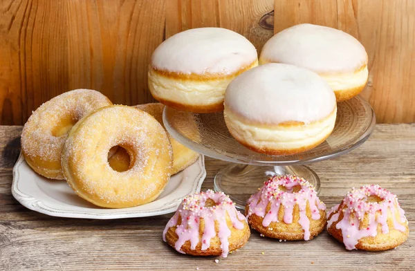 Donuts and easter cakes on wooden table. — Stock Photo, Image
