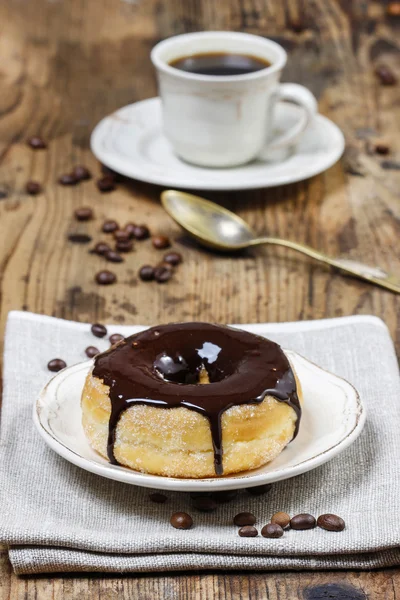 Delicious donut with chocolate on wooden table — Stock Photo, Image